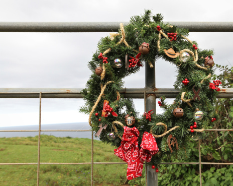 Cowboy themed Christmas Wreath hanging on a ranch gate in the tropics.