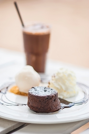 Chocolate cake with chocolate sauce and ice cream on white plate