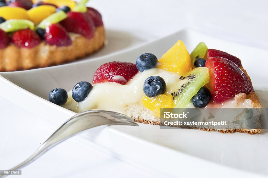 Fruitcake em um prato com garfo em fundo branco - Foto de stock de Amarelo royalty-free