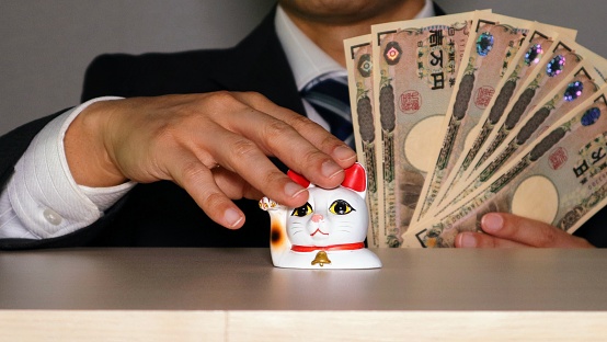 A picture of a businessman who got a lot of money from the beckoning cat