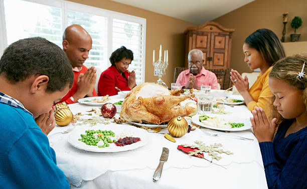 istock Multigenerational family praying before Christmas dinner 158431889