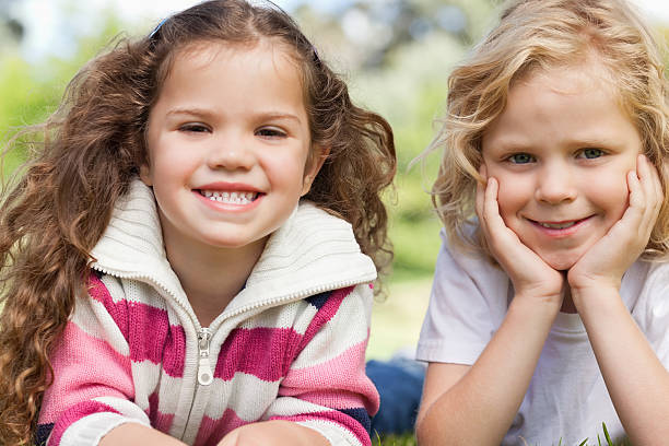istock Two friends smiling as they lie on their bellies 158432097