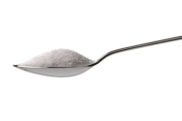 Sugar or salt on a teaspoon Sugar or salt on a teaspoon isolated on white teaspoon stock pictures, royalty-free photos & images