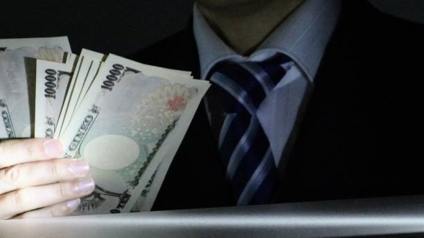istock Person holding banknotes in the dark 1584346286