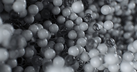 A close-up perspective revealing a collection of scattered black and white plastic and glass orbs, showcasing intricate patterns and textures.