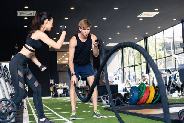 istock Young man doing gym exercise in battle ropes session. 1584359600