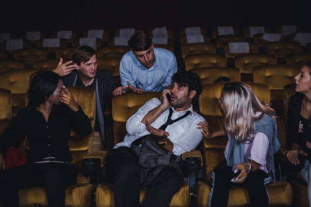 istock Woman admonish man for using cellphones in cinema. 1584366520