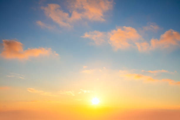 Pastel cloudscape. Sunrise sundown sky with light colorful clouds without any birds. With sun. stock photo