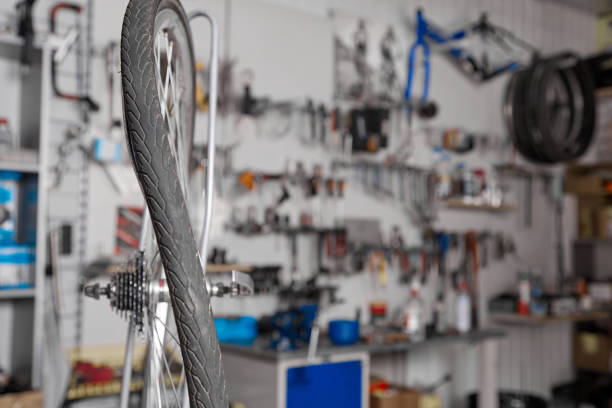 Close up deformation bicycle wheel in form eight. In professional bicycle service curved wheels are corrected. Repair deformed wheels in professional workshop against background of a rack with tools
