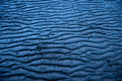 High angle view of tidal flats wave pattern with blue moonlight.