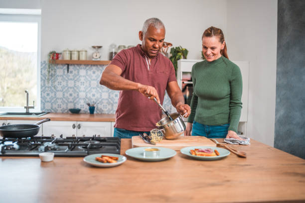 istock Cheerful Mature Multicultural Couple Creates Mealtime Magic at Home 1584389243
