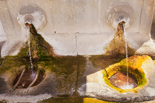 As Burgas Hot Spring stone fountain, Ourense city, Galicia, Spain. Roman origin. Close-up high angle view of two spurts.