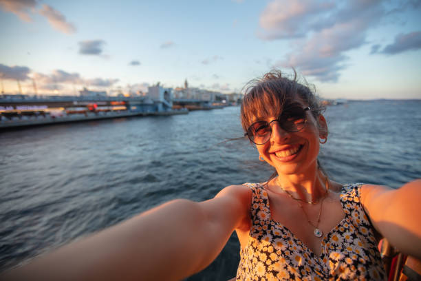 istock Pretty young lady is taking a selfie at sunset. 1584488424