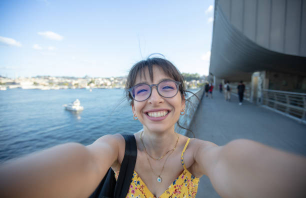 istock Pretty young woman is taking a selfie on the bridge. 1584490006