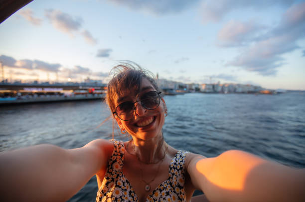 istock Pretty young lady is taking a selfie at sunset. 1584490540