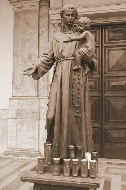 Statue of Saint Anthony of Padua with child in front of the church of Sant' Antonio di Padova,on the Via Merulana in Rome, Italy.