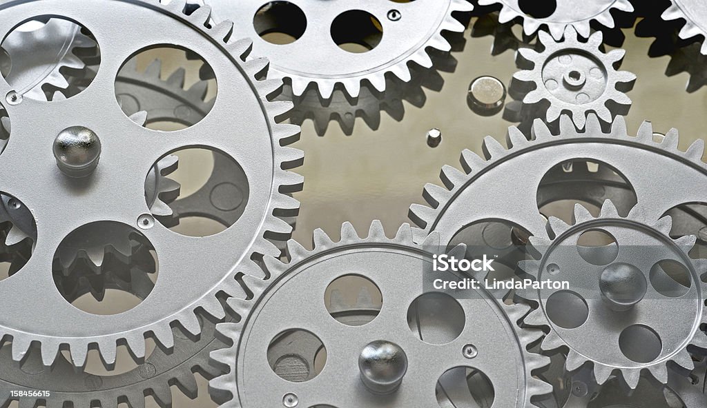 Gearing Silver gears interlocking with pewter background. Clockworks Stock Photo