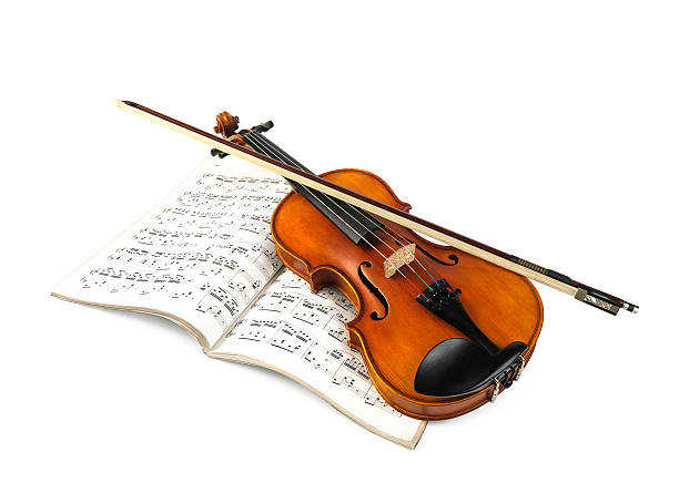 Violin and fiddle stick over score isolated on white stock photo