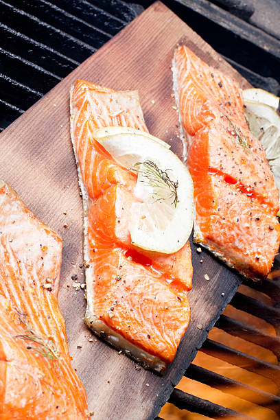 tre salmone alla griglia filets su cedar plank - lemon fruit portion citrus fruit foto e immagini stock