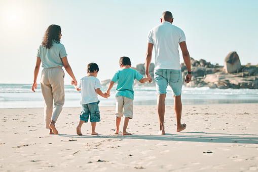 Shot of a happy young family having fun at the beach