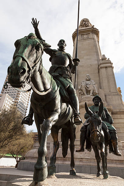 Monument of famous writer Miguel de Cervantes looking upon the bronze statue of his literature anti hero Don Quixote de la Mancha riding his horse Rocinante and accompanied by his squire Sancho Panza at the Plaza de España in Madrid, Spain. It was designed by Rafael Martínez Zapatero, Pedro Muguruza and Lorenzo Coullaut Valera. The monument was built between 1925 and 1930, but finished in 1957 by Federico Coullaut-Valera Mendigutia.