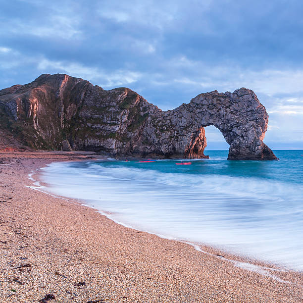 Durdle Door Durdle Door in Dorset with two kayakers jurassic coast world heritage site stock pictures, royalty-free photos & images