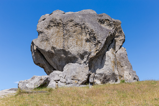 Single sandstone rock, as the erosive remains of the ancient sea reef, on the hill top on a background of clear sky in summer. Geological monument of nature, Pidkamin village, Ukraine