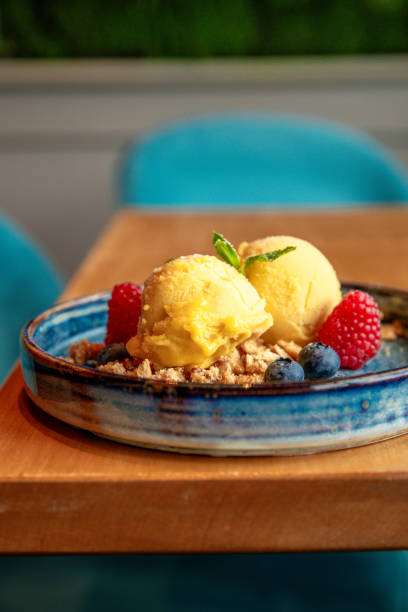 Yellow Ice Cream Dessert plate with Mango Ice cream scoops and berries