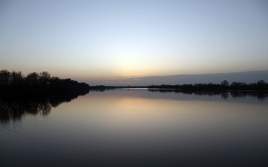 A reflection shot of a British lake at sunset.
