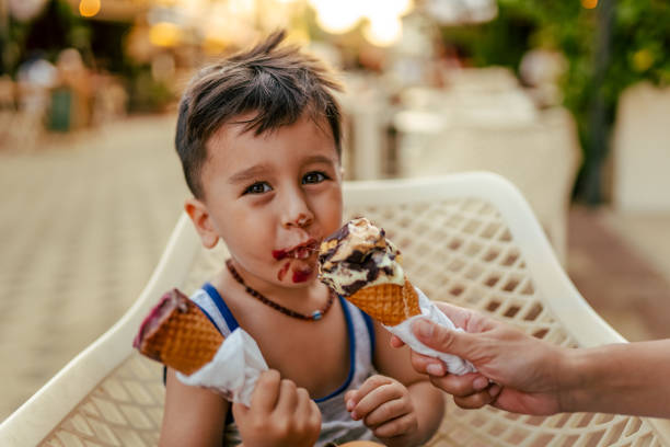 istock Cute little boy enjoy eating ice cream at summer 1584649949