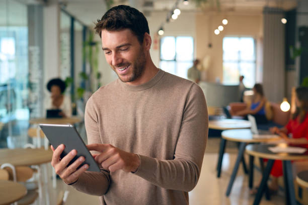 istock Businessman Standing In Busy Office Using Digital Tablet 1584656327