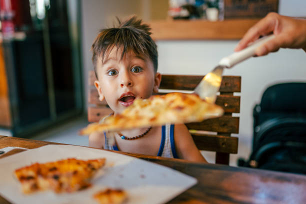 istock Hungry Baby boy eating Pizza 1584664779