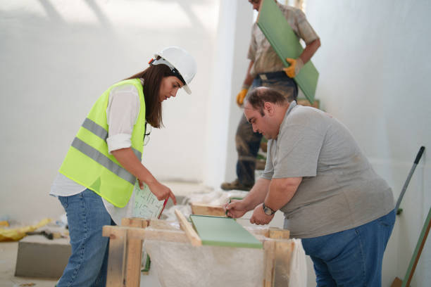 istock The female engineer is talking with the workers at the construction site. 1584673571