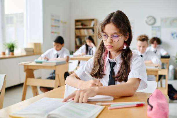 istock Schoolgirl studying at her desk 1584675719