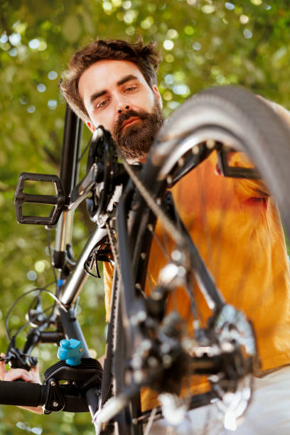 istock Male cyclist examining bicycle parts 1584676833