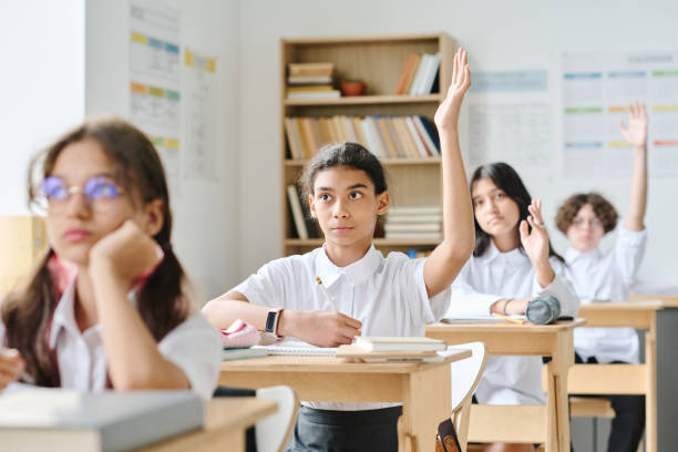 istock Schoolgirl answering at lesson at school 1584679659
