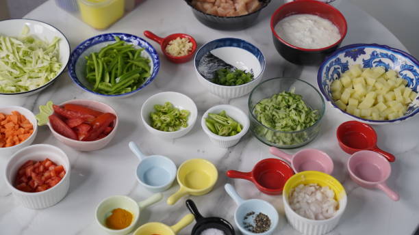 All Ingredients on a white table, yogurt, red and black pepper, chopped onions and tomato and potatoes etc. All Ingredients on a white table, yogurt, red and black pepper, chopped onions and tomato and potatoes etc. cabbage coral photos stock pictures, royalty-free photos & images