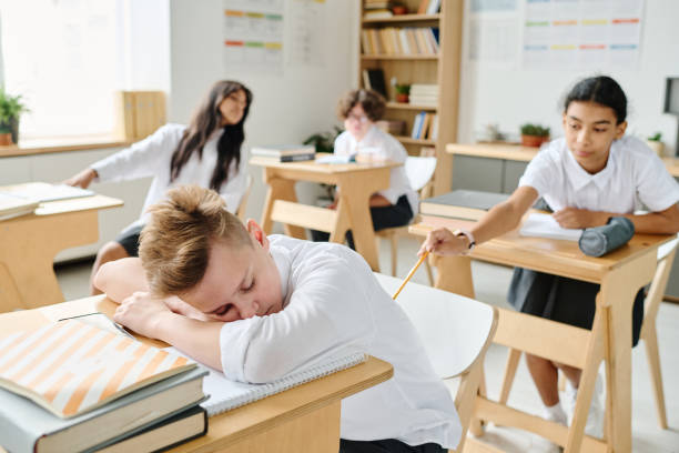 istock Schoolboy sleeping at desk at lesson 1584680228