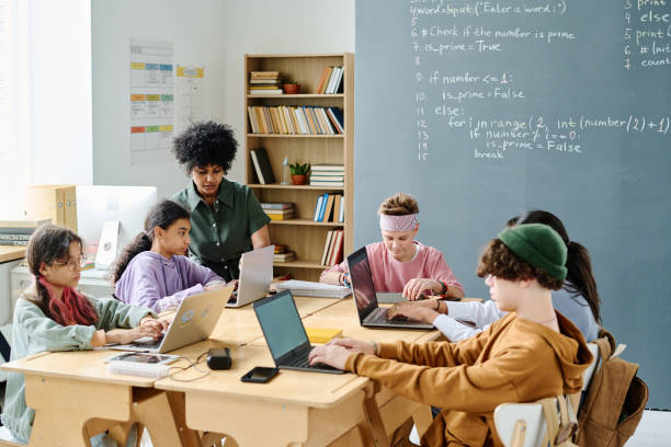 istock School children studying IT together with teacher 1584682341