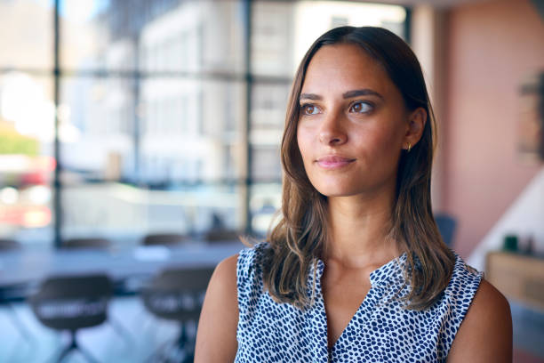 istock Portrait Of Young Businesswoman With Serious Expression Standing In Empty Office 1584682995