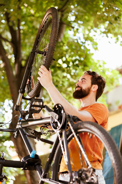 istock Man holding bike wheel for maintenance 1584683329