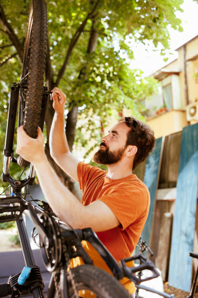 istock Male cyclist fastening bicycle tire 1584683584