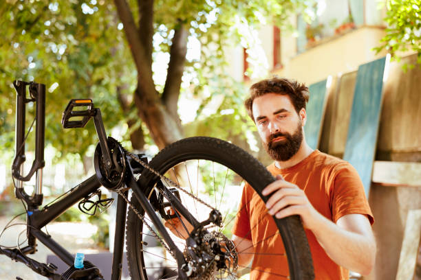 istock Young man gripping damaged bicycle wheel 1584683924
