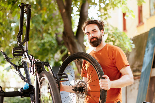 istock Man reattaching bicycle wheel outside 1584684513
