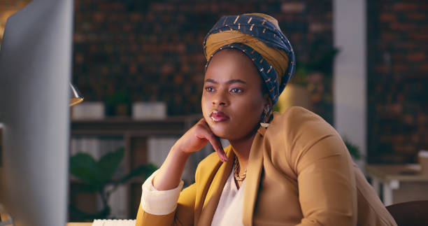 istock Night, office computer and black woman reading journalism story, check email communication or blog post. Reporter focus, late online research and African business person review social media article 1584690053