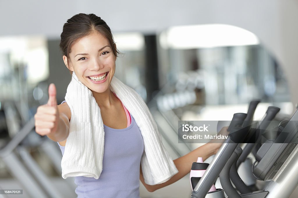 Happy fitness woman thumbs up in gym Happy fitness woman thumbs up in gym during exercise training on moonwalker treadmill.. Thumbs Up Stock Photo