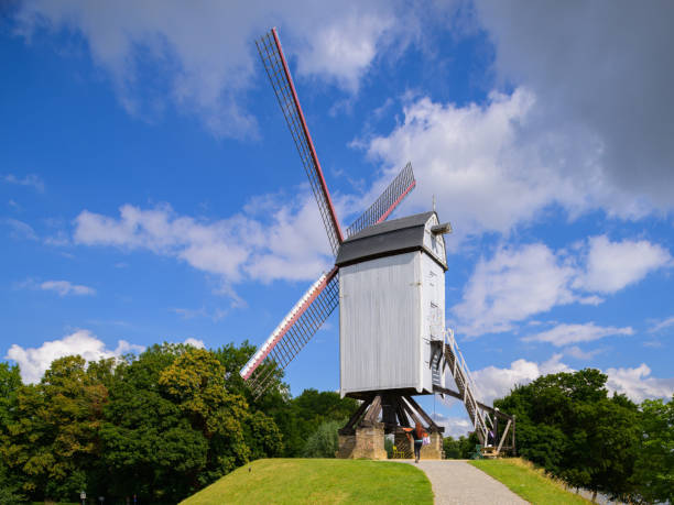 un molino de viento parado en una colina en brujas - belgium bruges windmill europe fotografías e imágenes de stock