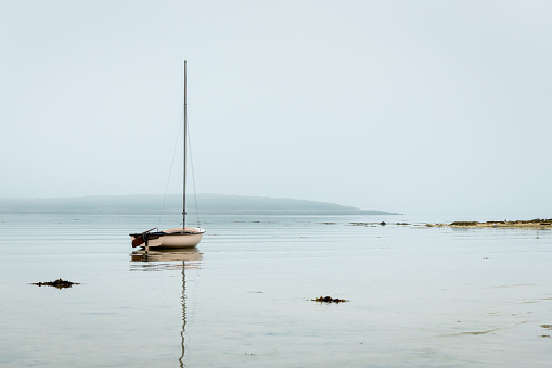Lannilis, France - August 12, 2020: A lonely sailboat in the sea near the coast , morning, daylight