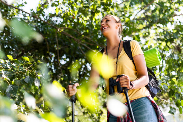 istock Female Backpacker Traveling Alone using hiking poles 1584710951