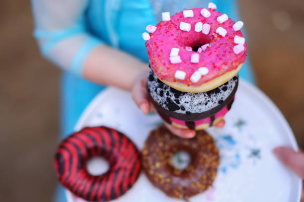 istock different donuts on the children hands, Pink and chocolate donuts 1584716450